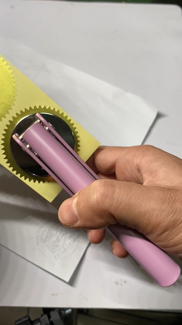 Handheld embosser being pressed for functional verification of POM dies