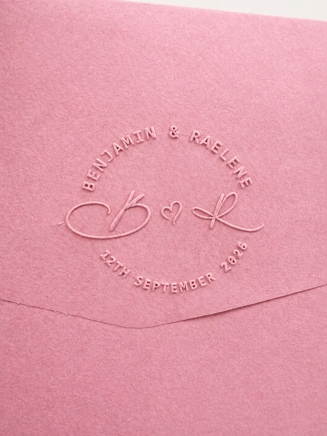 Custom embossed impression on a pink envelope